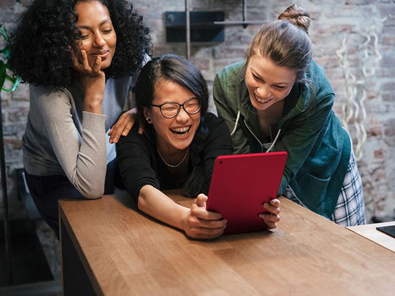 women at table looking at tablet